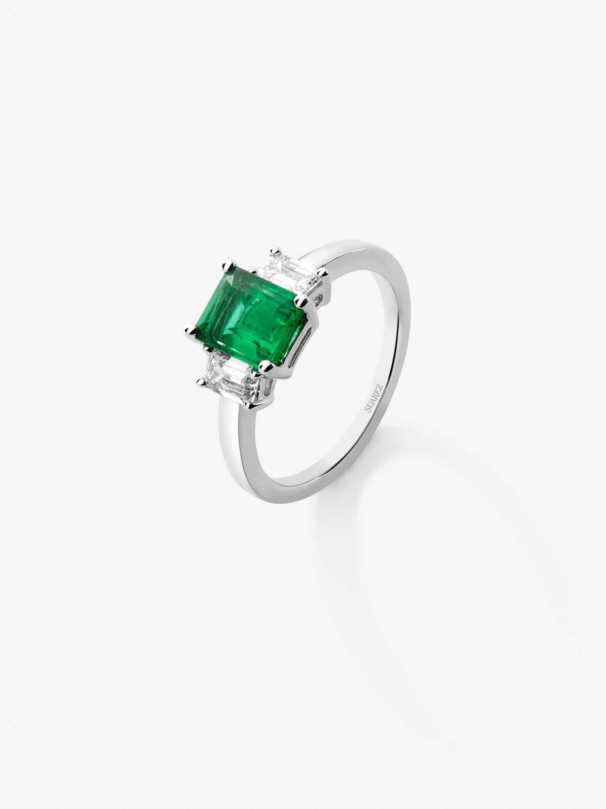 Anillo tresillo de oro blanco de 18K con esmeralda en talla octogonal de 0 5 cts y 2 diamantes en talla esmeralda con un total de 0 31 cts Suarez