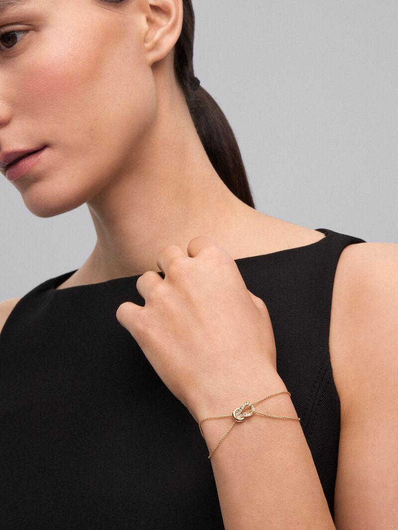 18K yellow gold bracelet with 17 brilliant-cut diamonds with a total of 0.15 cts and a knot shape image number 1
