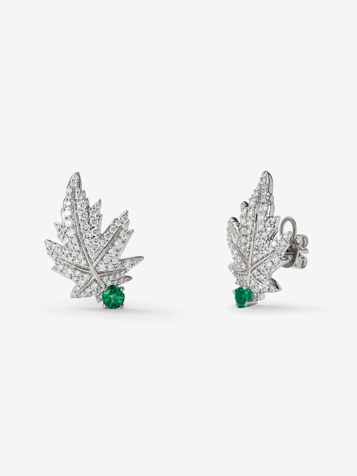 Pendientes de oro blanco de 18K con 2 esmeraldas centrales con un total de 0,28 cts, pavé de diamantes y forma de hoja de arce