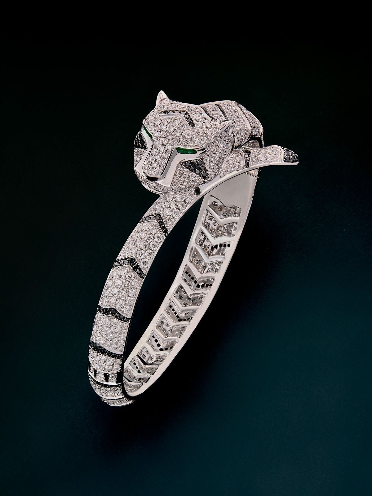 Rigid 18K white gold bracelet with 747 brilliant-cut white diamonds with a total of 8.17 cts, 241 brilliant-cut black diamonds with a total of 1.49 cts and 2 trapezoid-cut emeralds with a total of 0.13 tiger shaped cts