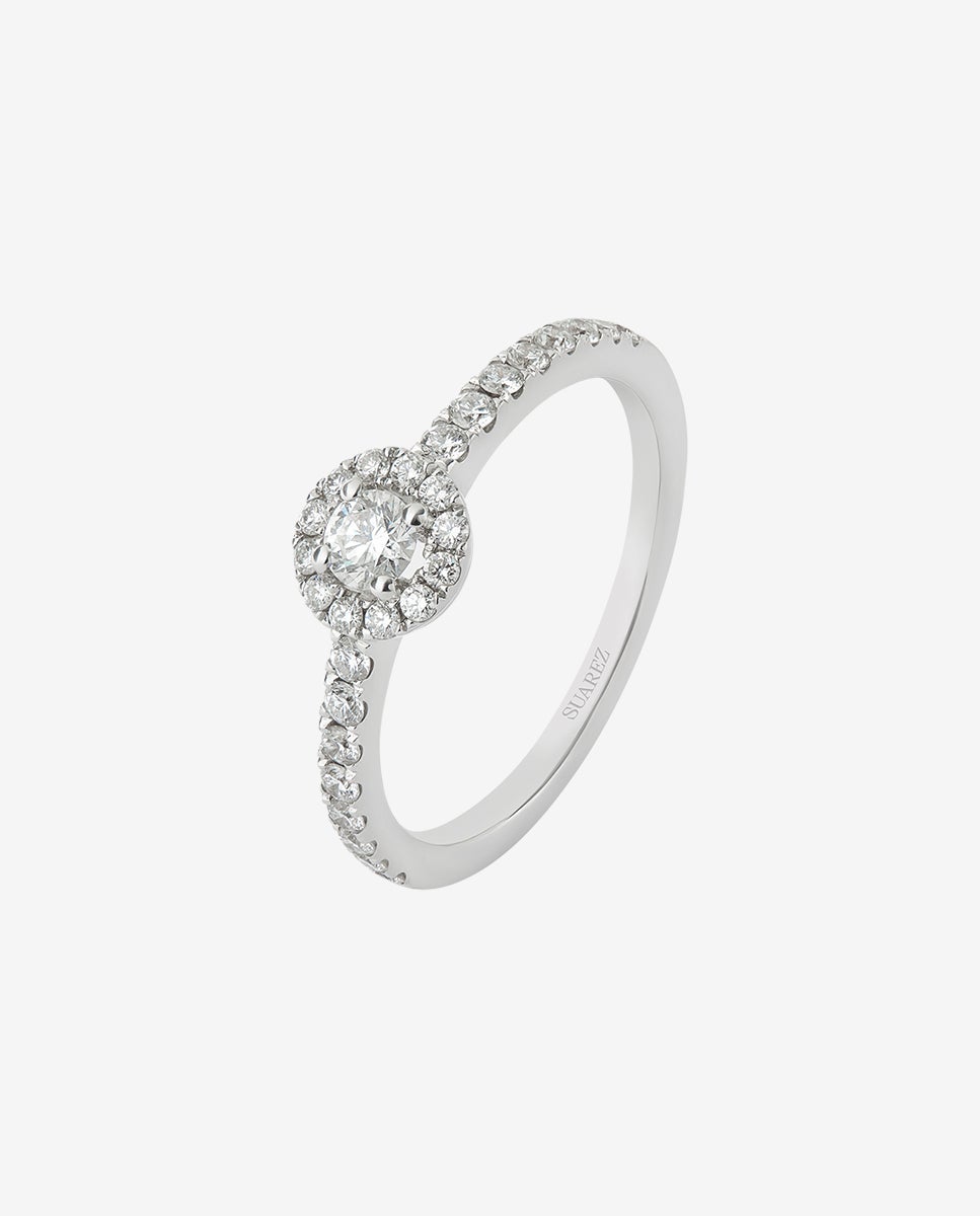 Anillo de oro blanco de 18K con diamante central en talla brillante de 0,15 cts y orla y brazo de 28 diamantes en talla brillante con un total de 0,3 cts