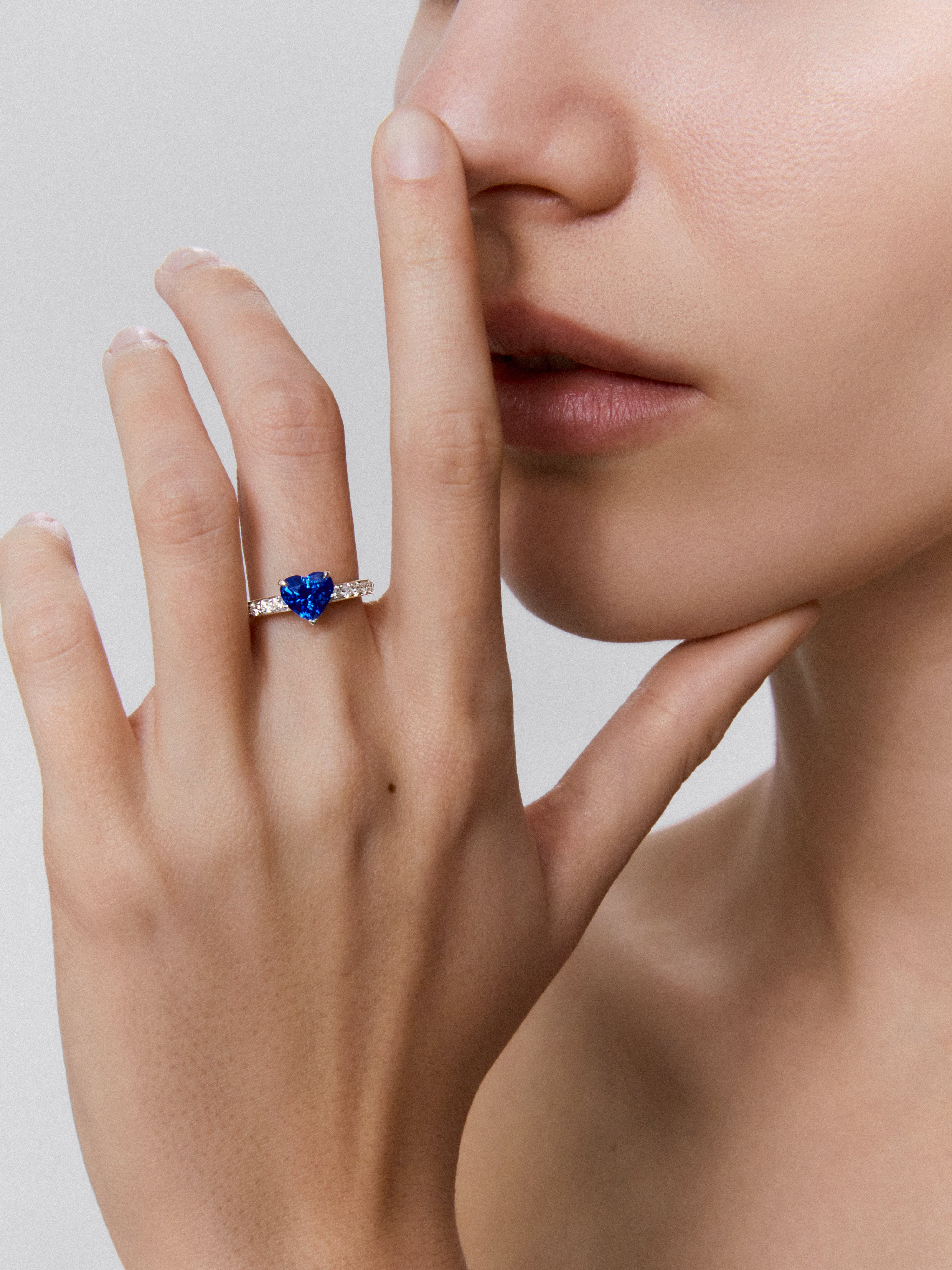 Anillo de oro blanco de 18K con zafiro azul en talla corazón de 1,6 cts y 14 diamantes en talla brillante con un total de 0,36 cts