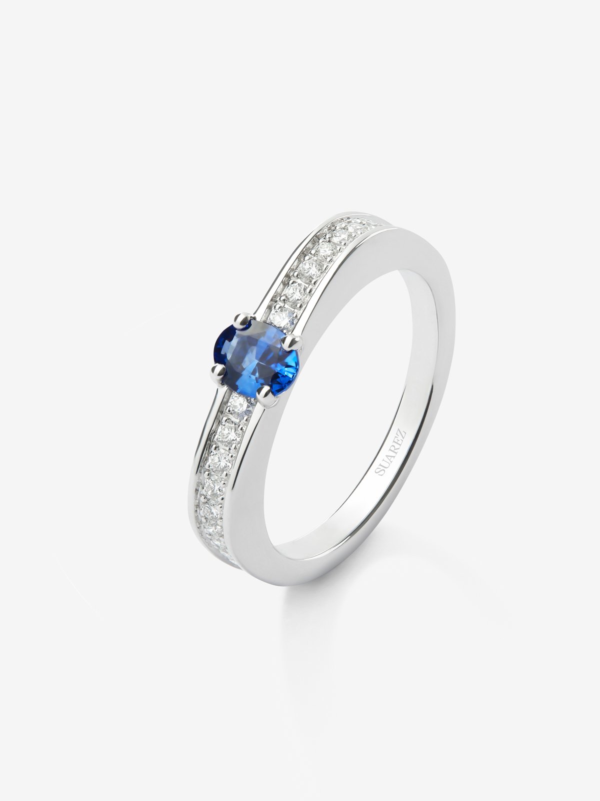 Anillo de oro blanco de 18K con zafiro azul en talla oval de 0,47 cts y 22 diamantes en talla brillante con un total de 0,16 cts