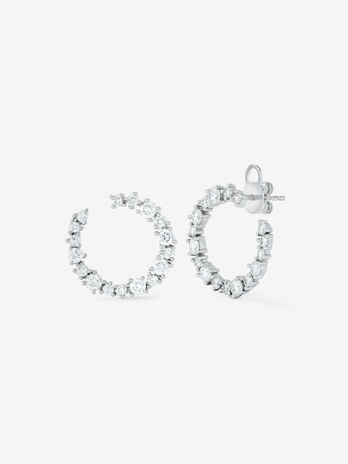 Side hoop earrings made of 18K white gold with claw-set diamonds.
