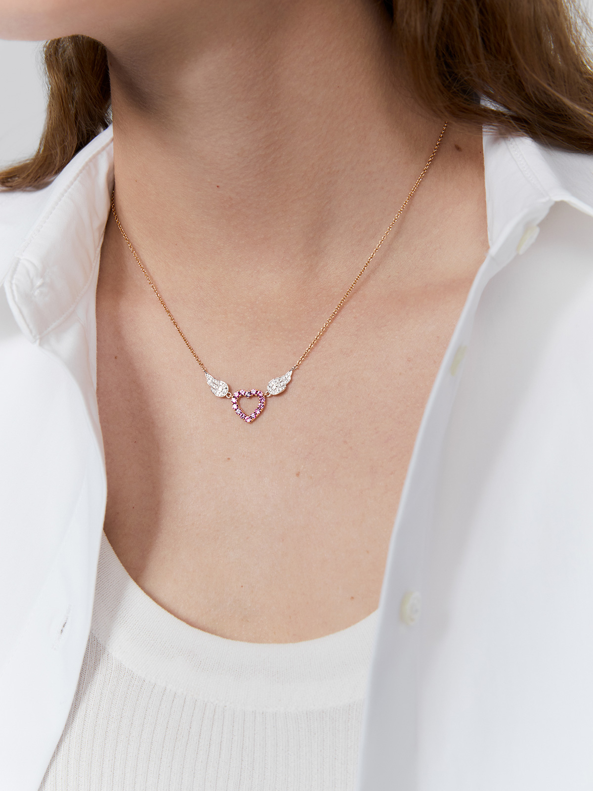 Heart pendant with rose gold and 18kt white gold wings adorned with pink sapphires and diamonds.