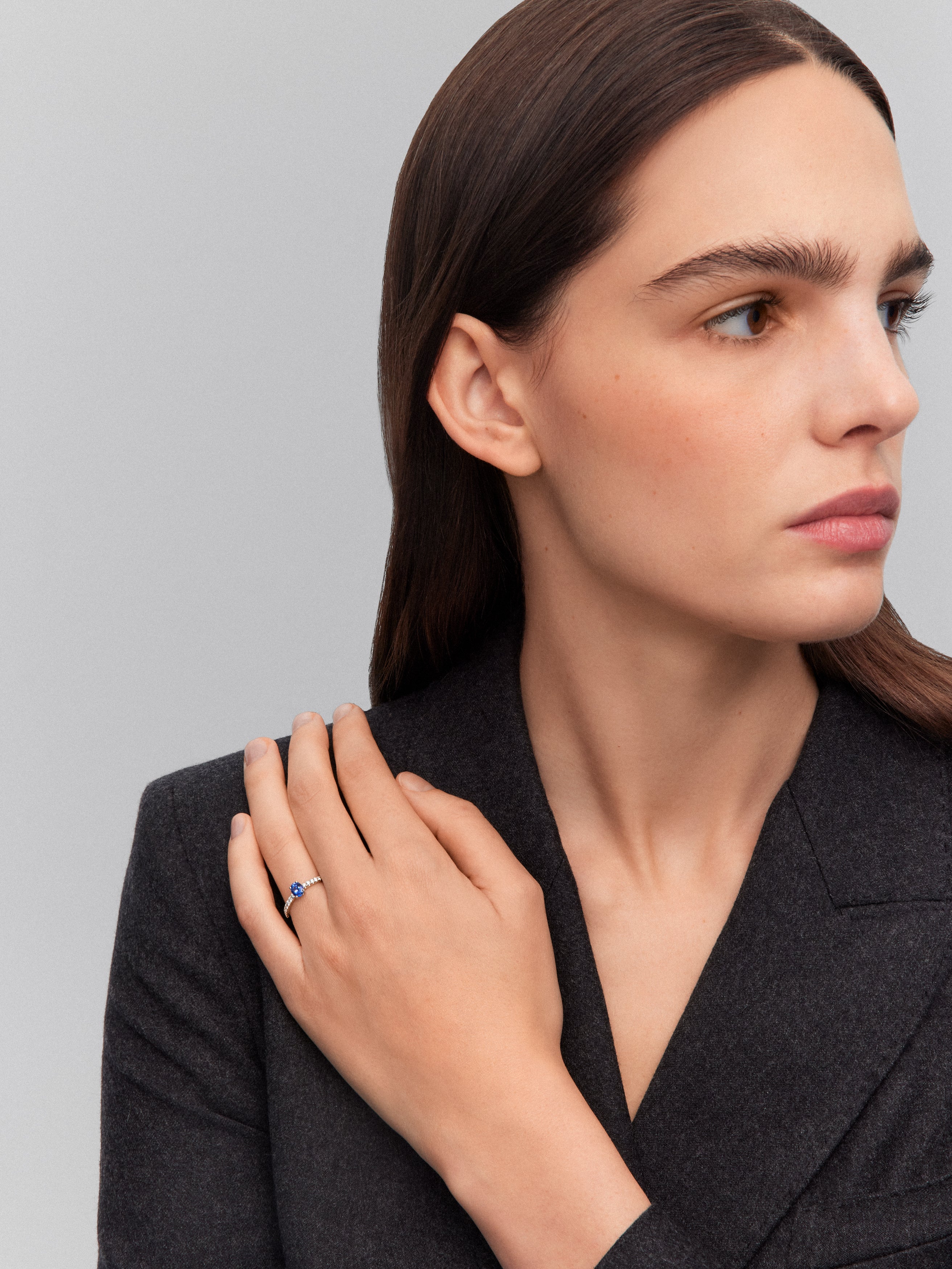Anillo solitario de oro blanco de 18K con zafiro azul en talla oval de 0,89 cts y 16 diamantes en talla brillante con un total de 0,3 cts