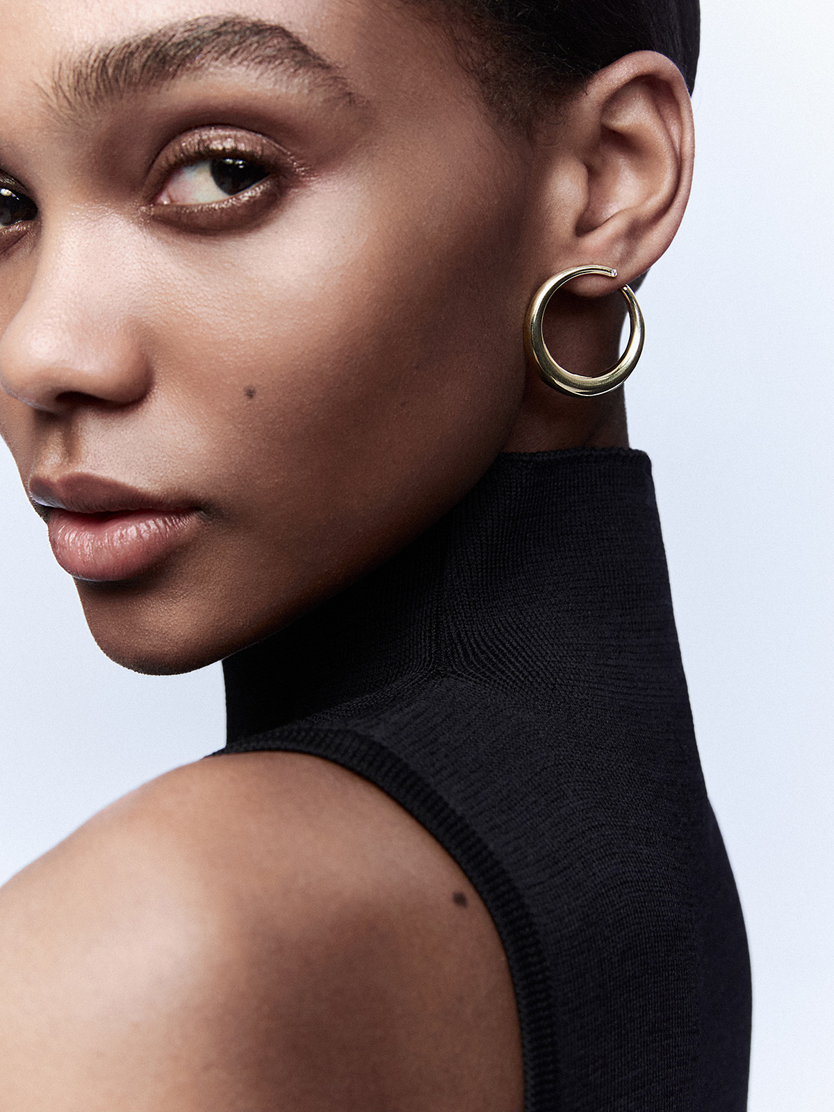 Large smooth hoop earrings in 18K yellow gold with diamond.
