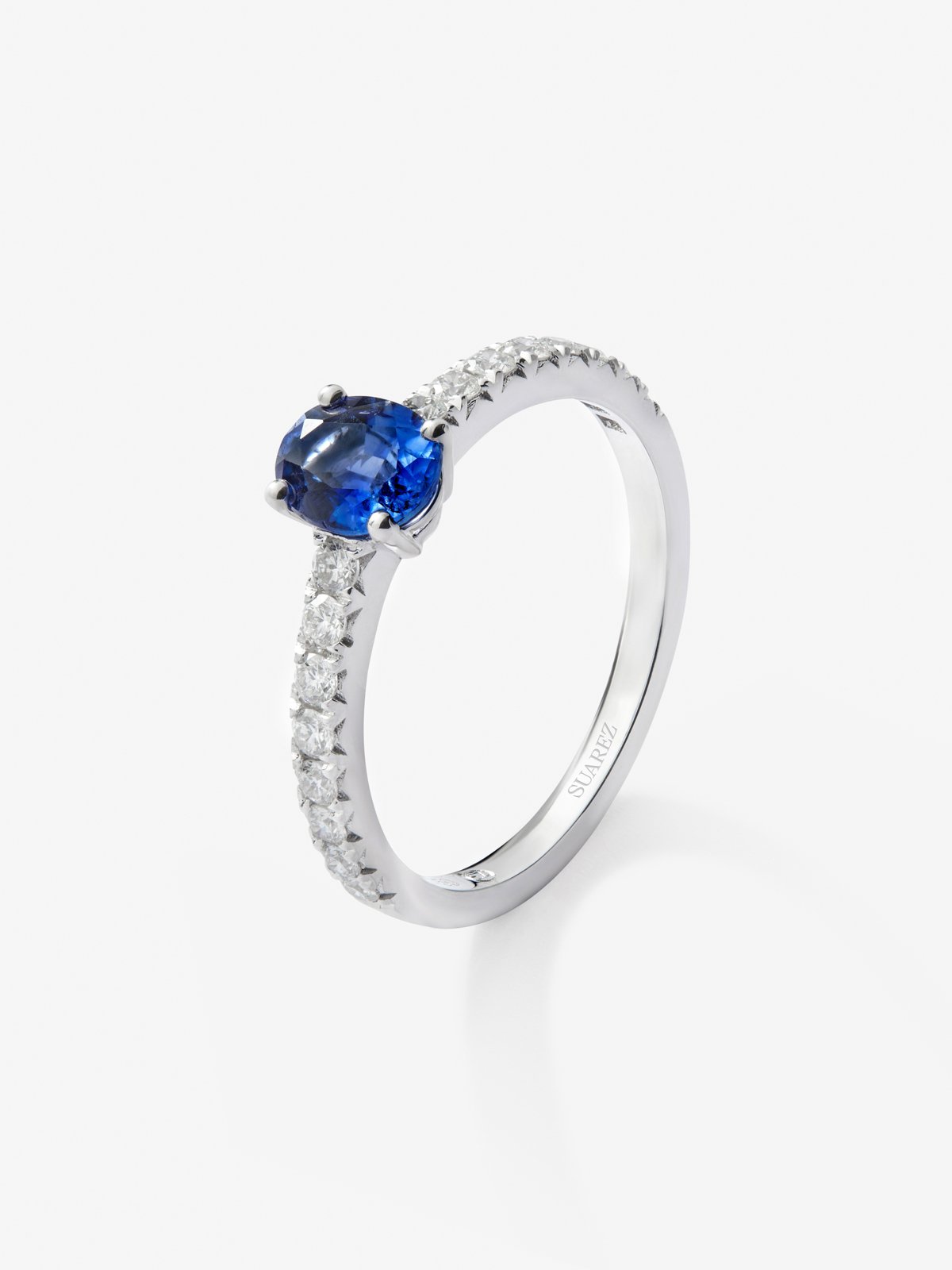 Anillo solitario de oro blanco de 18K con zafiro azul en talla oval de 0,89 cts y 16 diamantes en talla brillante con un total de 0,3 cts