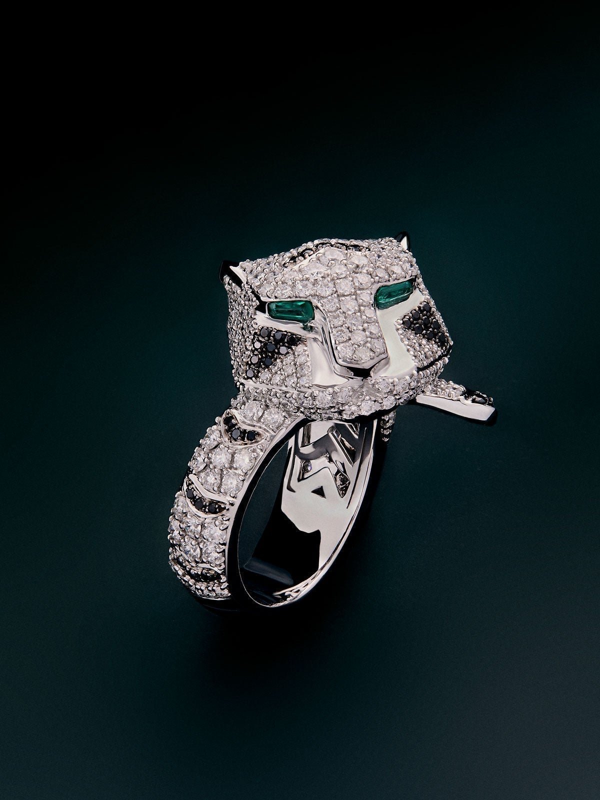 18K white gold ring with 278 brilliant-cut white diamonds with a total of 1.87 cts, 55 brilliant-cut black diamonds with a total of 0.25 cts, and trapezoid-cut emeralds with a total of 0.13 cts tiger-shaped