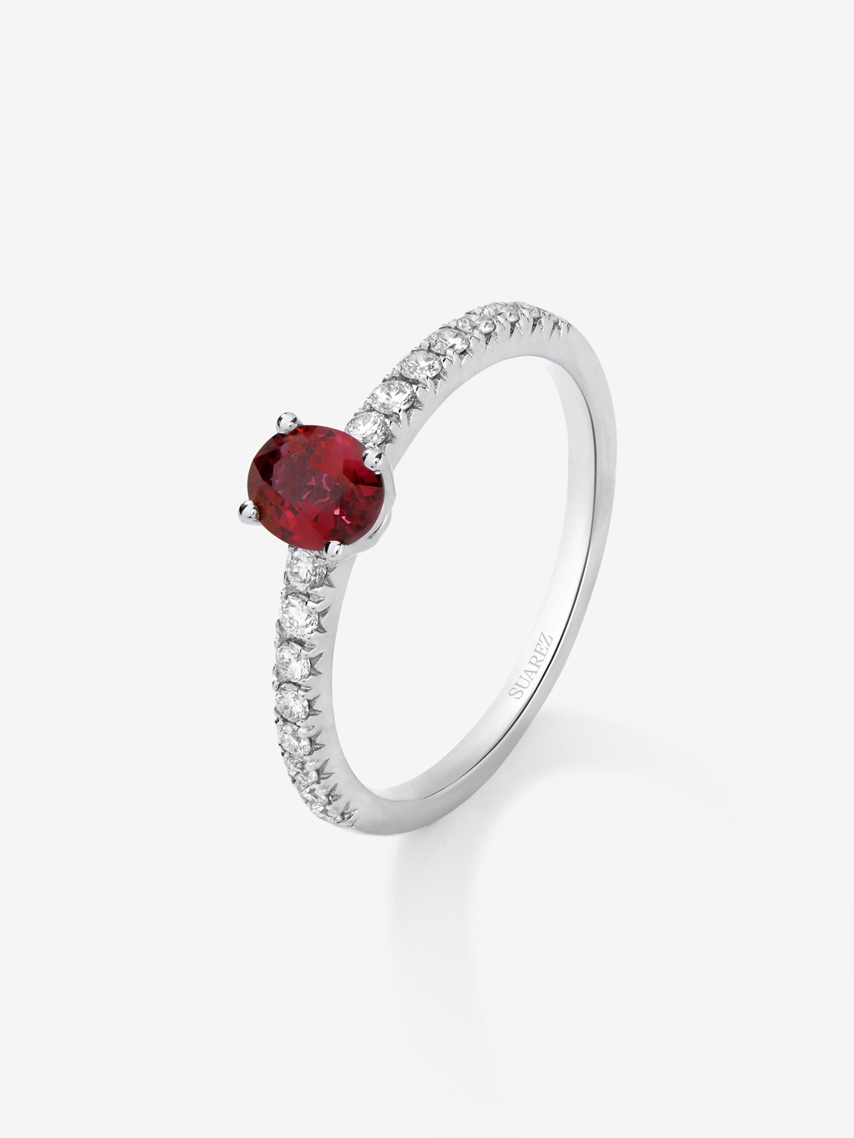 Anillo de oro blanco de 18K con rubí rojo en talla oval de 0,63 cts y 16 diamantes en talla brillante con un total de 0,22 cts