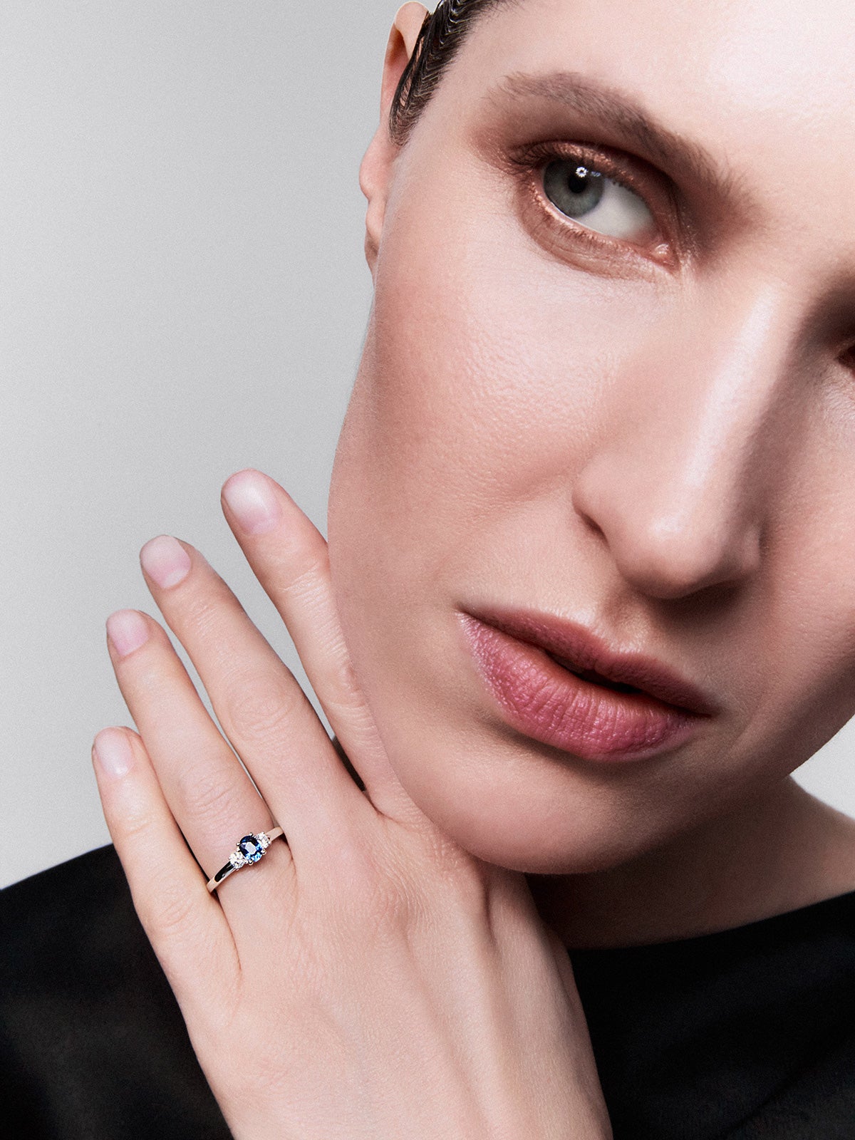 Anillo tresillo de oro blanco de 18K con zafiro azul en talla oval de 0,48 cts y 2 diamantes en talla brillante con un total de 0,24 cts