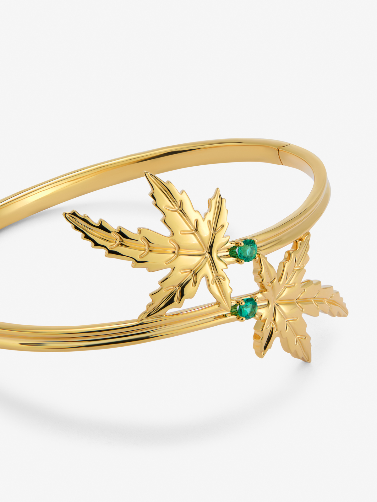 18K yellow gold bracelet with two brilliant-cut emeralds totaling 0.23 cts, in a maple leaf design.
