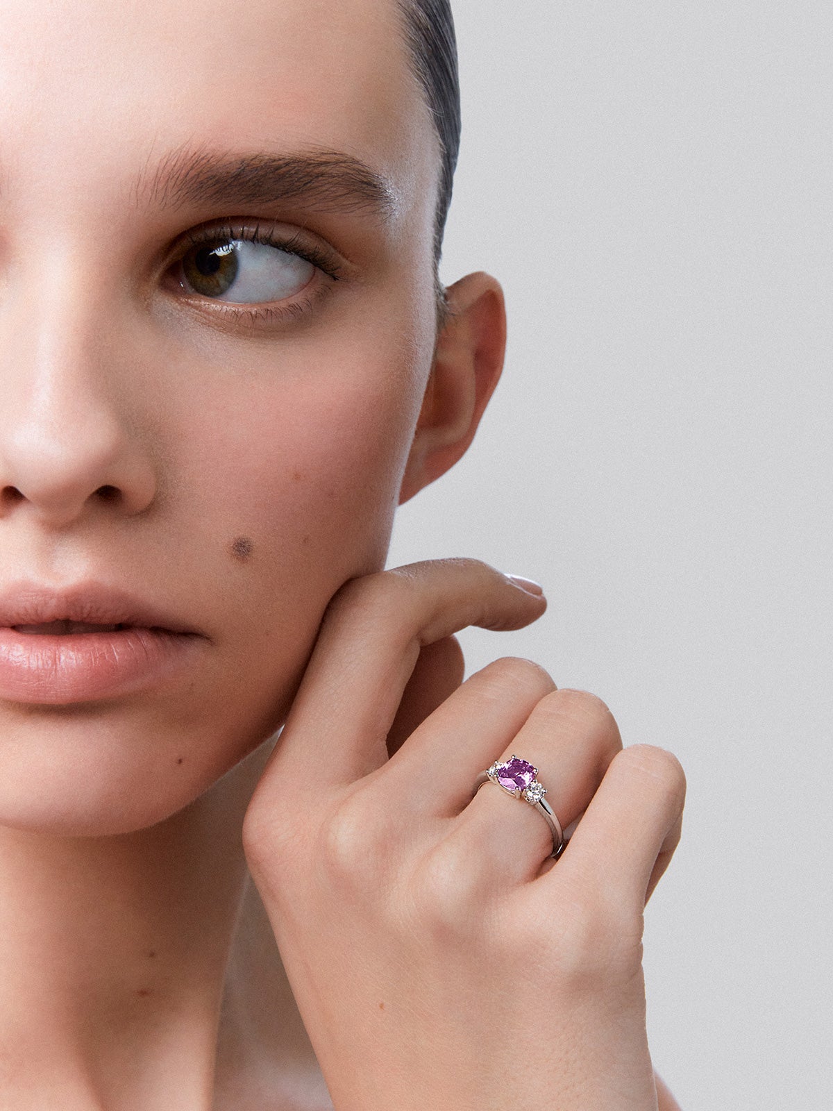 18kt white gold three-stone ring with a central 1.21cts cushion-cut pink sapphire and diamonds.