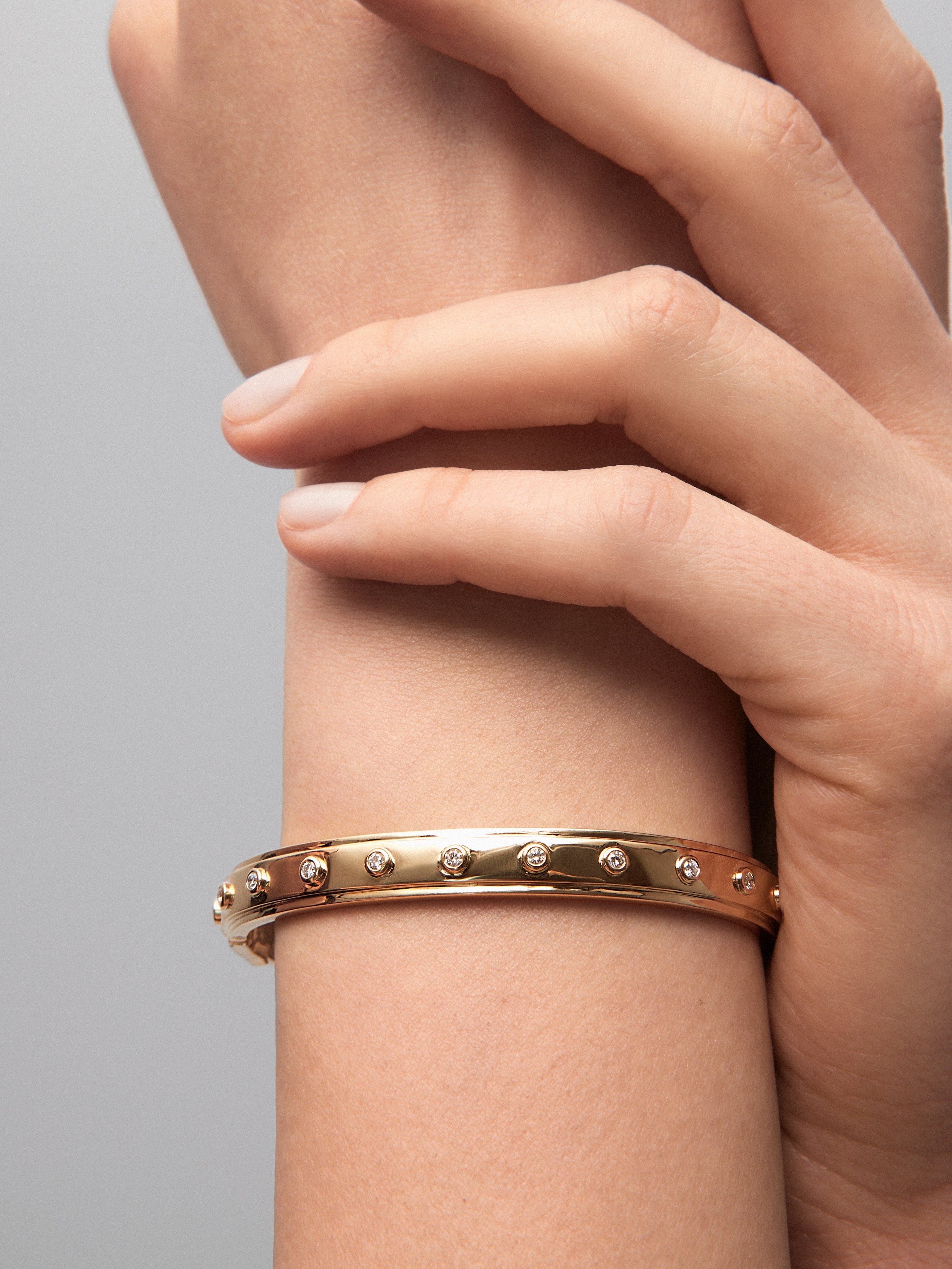 Pulsera rígida de oro amarillo de 18K con 11 diamantes en talla brillante con un total de 0,36 cts