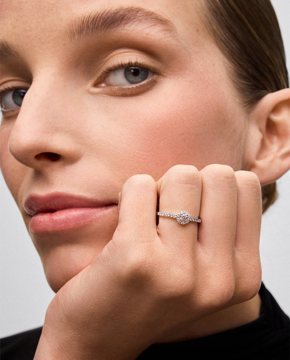 Anillo de oro blanco de 18K con diamante central en talla brillante de 0,15 cts y orla y brazo de 28 diamantes en talla brillante con un total de 0,3 cts
