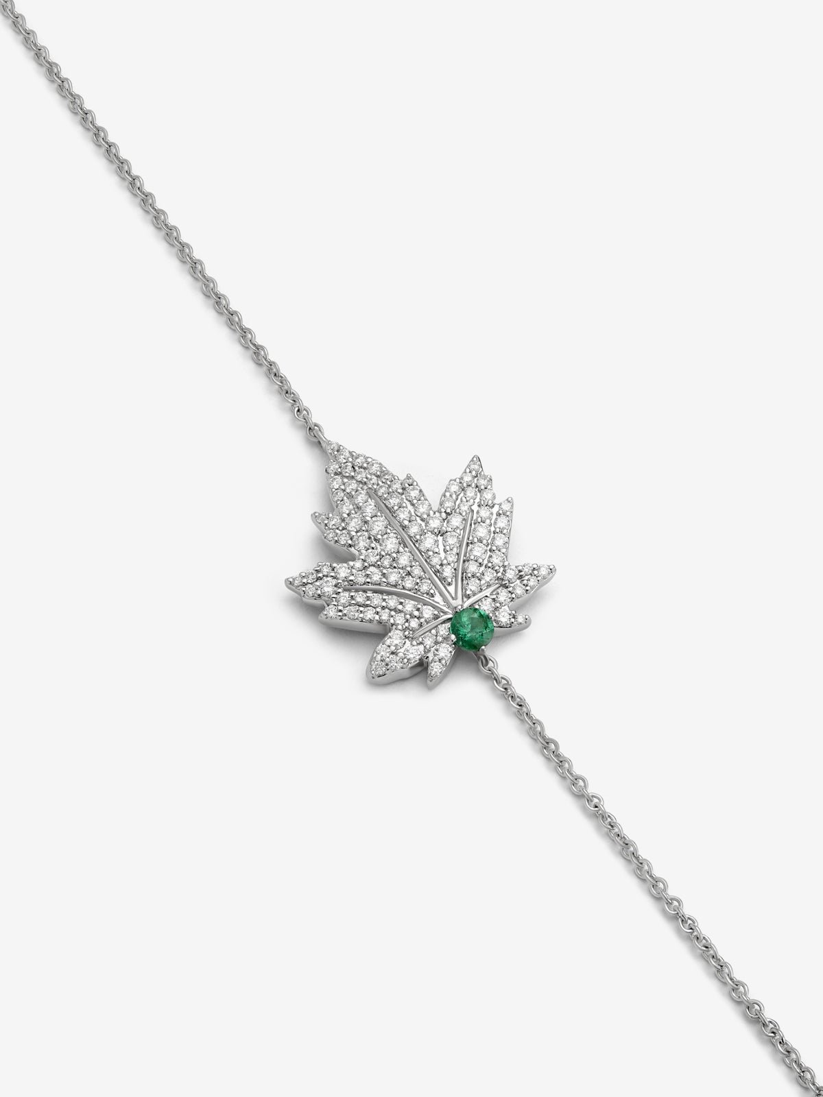 Pulsera de oro blanco de 18K con esmeralda central de 0,1 cts, pavé de diamantes y forma de hoja de arce