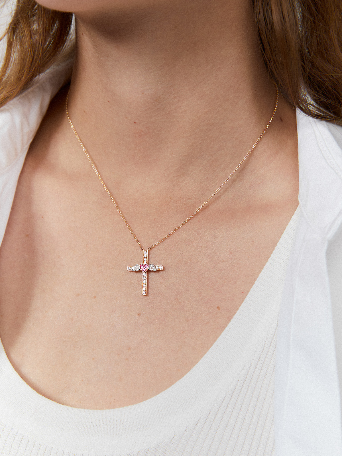 Cross and heart pendant with wings made of 18kt rose gold, adorned with diamonds and pink sapphires.