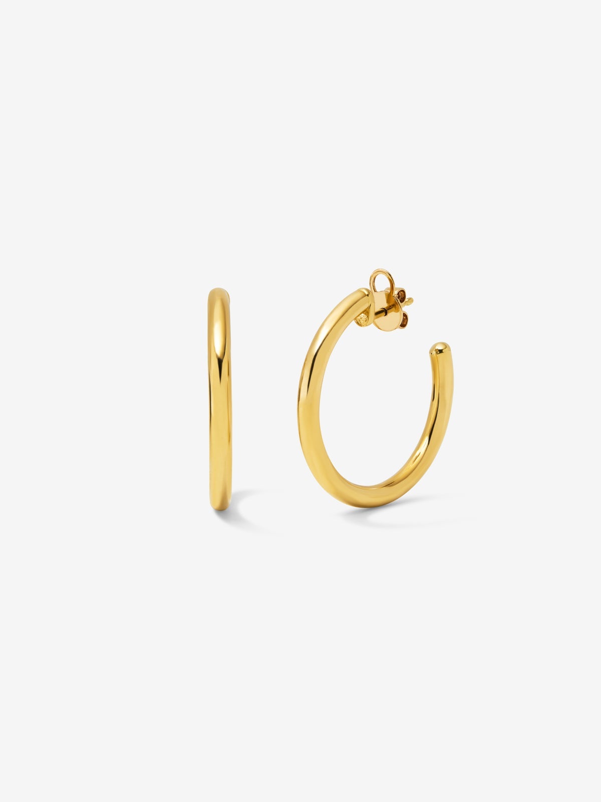 Medium smooth hoop earrings in 18K yellow gold.