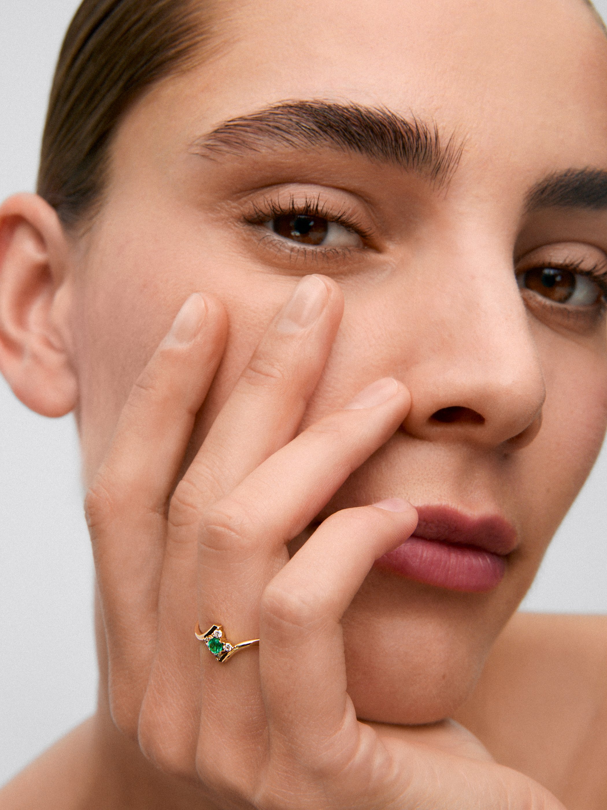 Anillo de oro amarillo de 18K con esmeralda verde en talla brillante de 0,088 cts y 4 diamantes en talla brillante con un total de 0,08 cts