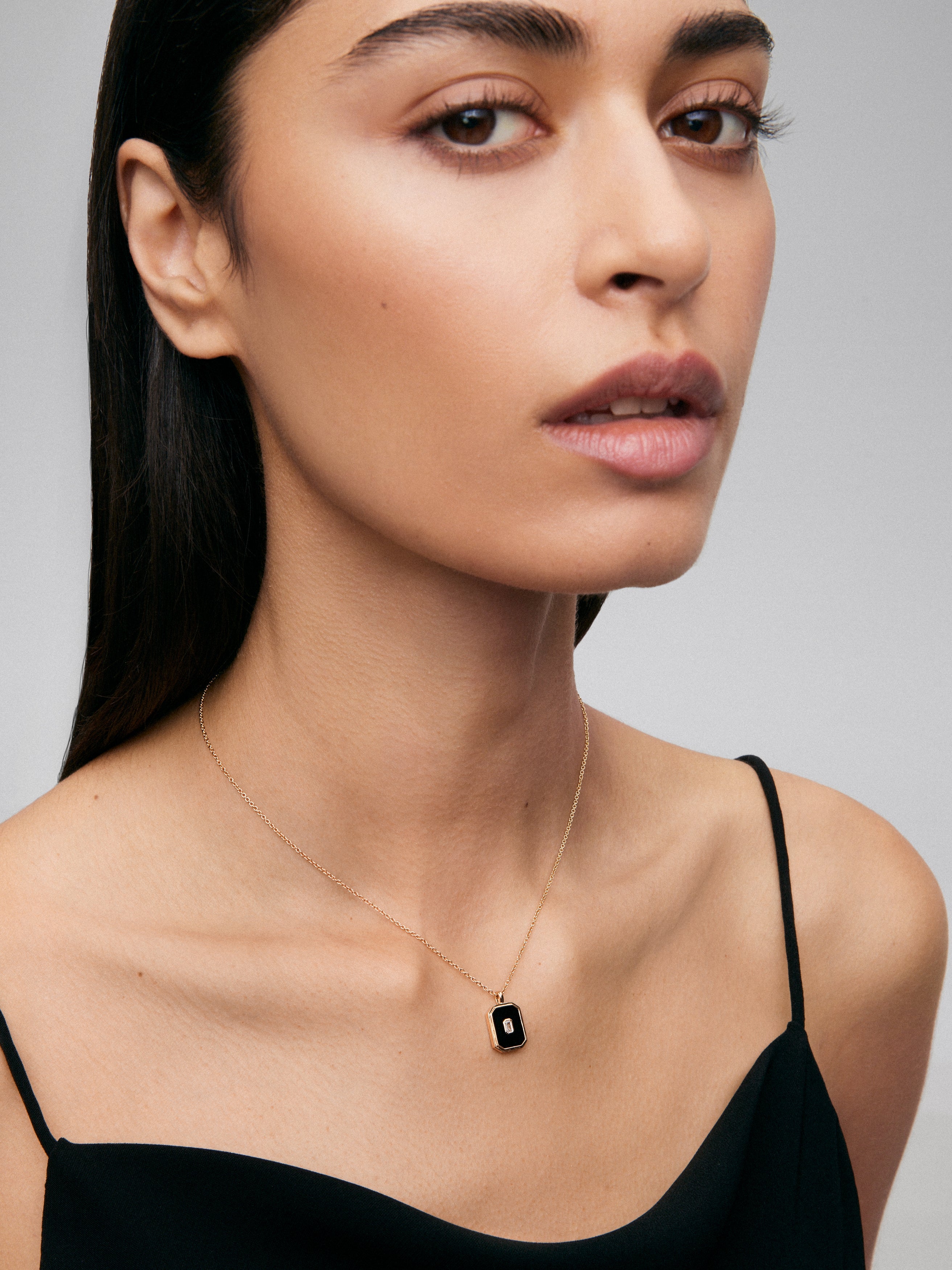 Colgante de oro amarillo de 18K con ónix negro de 1,45 cts y diamante blanco en talla esmeralda de 0,1 cts