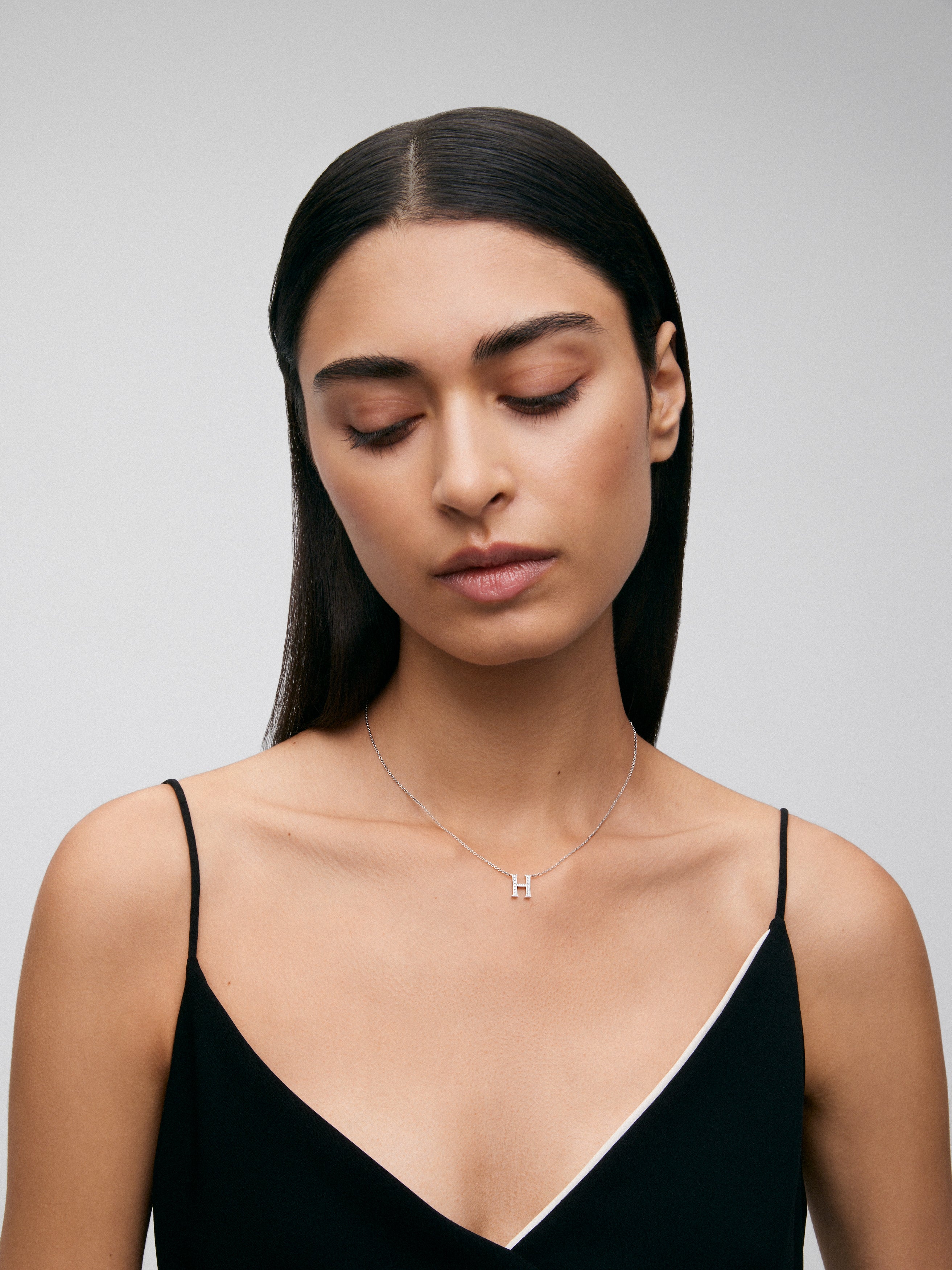 Colgante de oro blanco de 18K con letra H y diamantes en talla brillante