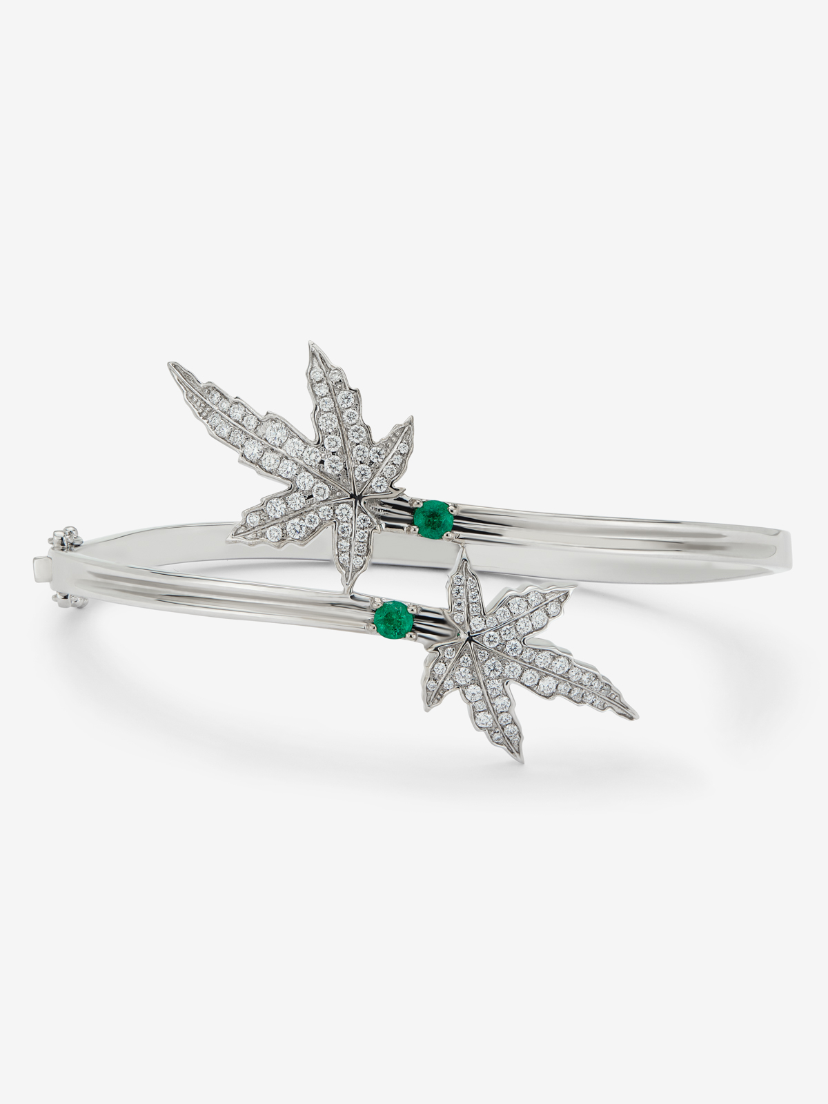 18K white gold bracelet with two central emeralds totaling 0.24 cts, diamond pavé, and a maple leaf design.