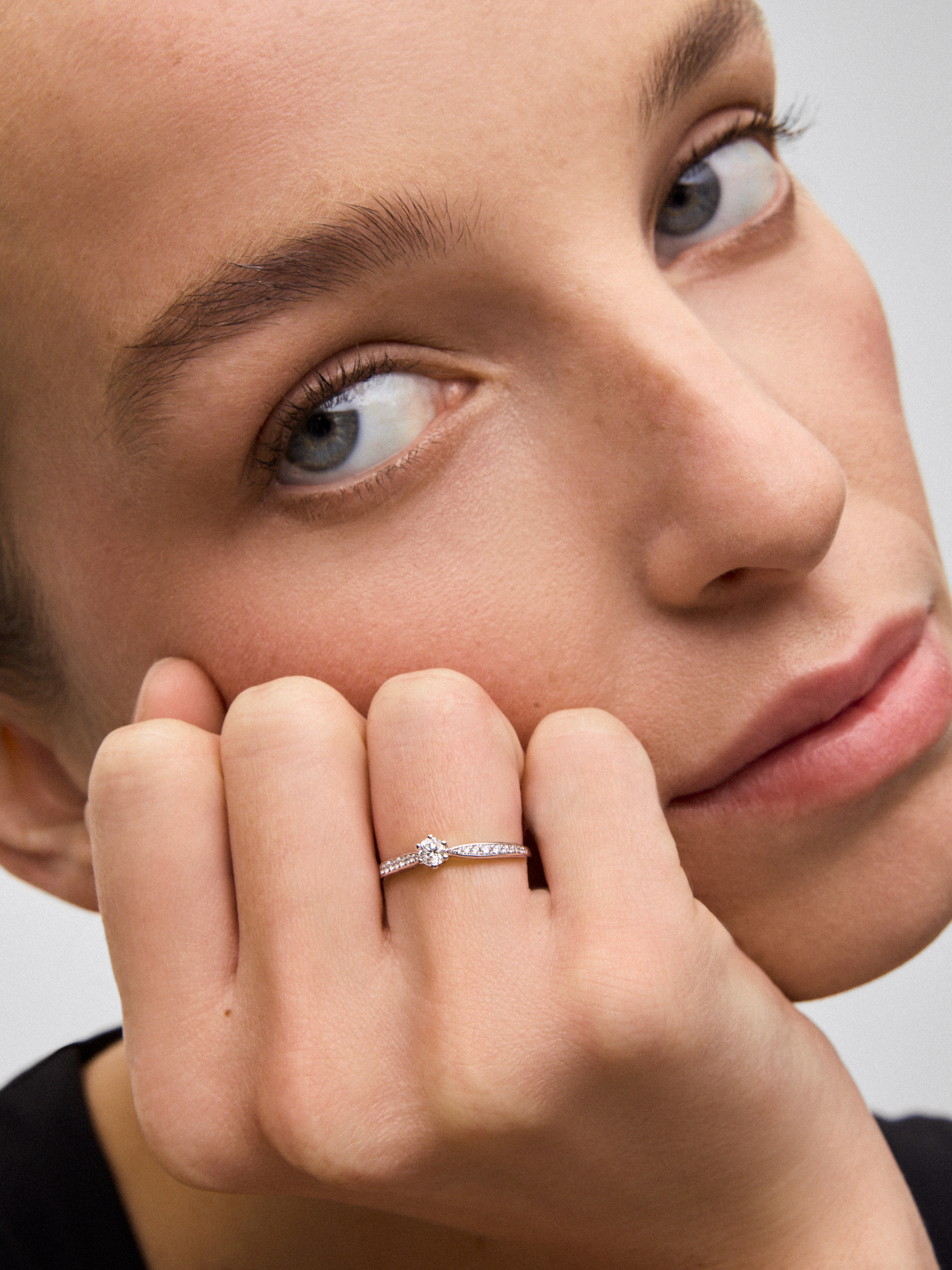 Anillo solitario de oro blanco de 18K con diamante central en talla brillante de 0,20 cts y diamantes en talla brillante con un total de 0,10 cts