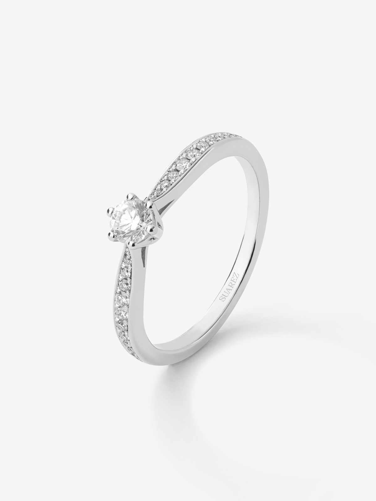 Anillo solitario de oro blanco de 18K con diamante central en talla brillante de 0,20 cts y diamantes en talla brillante con un total de 0,10 cts