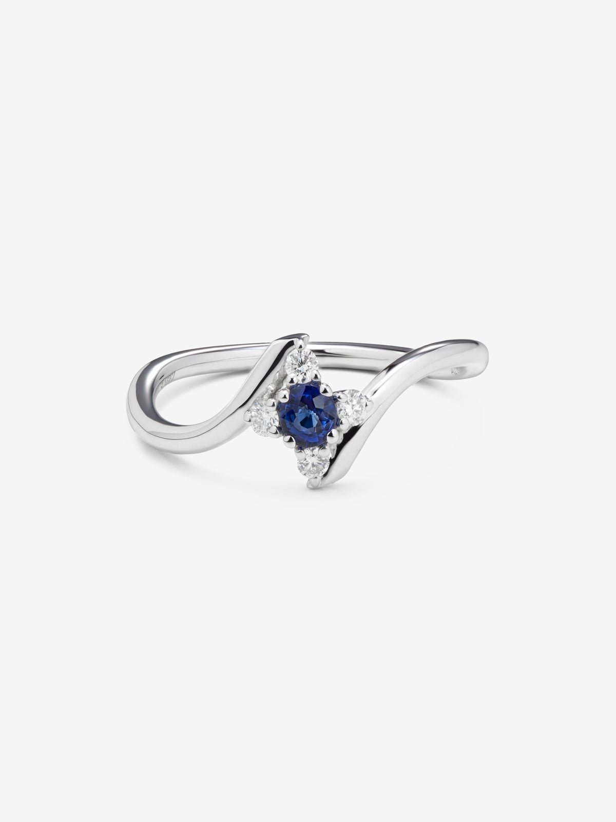 Anillo de oro blanco de 18K con zafiro azul en talla brillante de 0,15 y 4 diamantes en talla brillante con un total de 0,08 cts