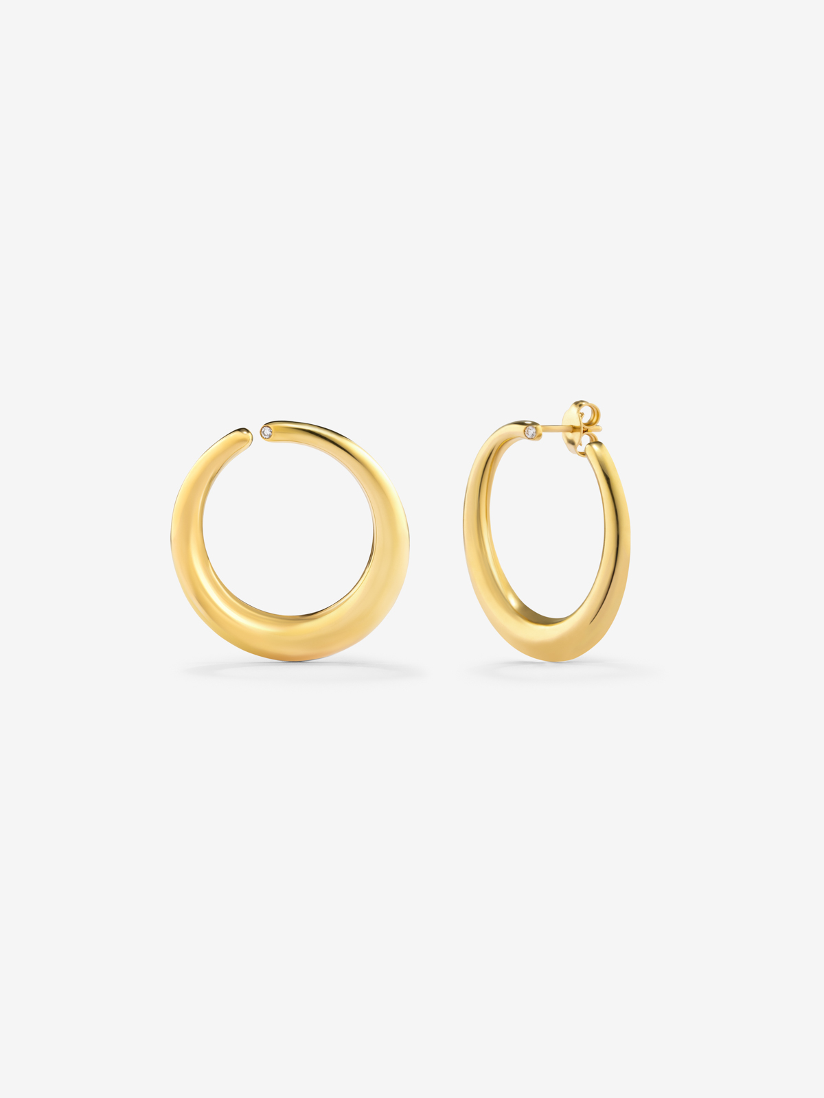 Large smooth hoop earrings in 18K yellow gold with diamond.