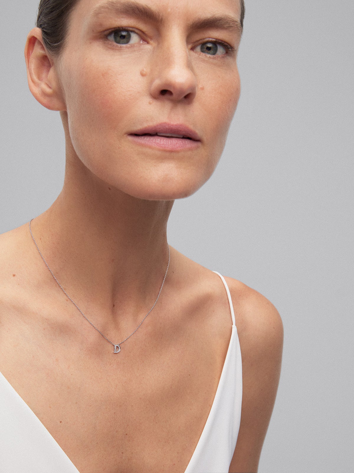 Pendant necklace with a small initial of 18K white gold and diamonds.