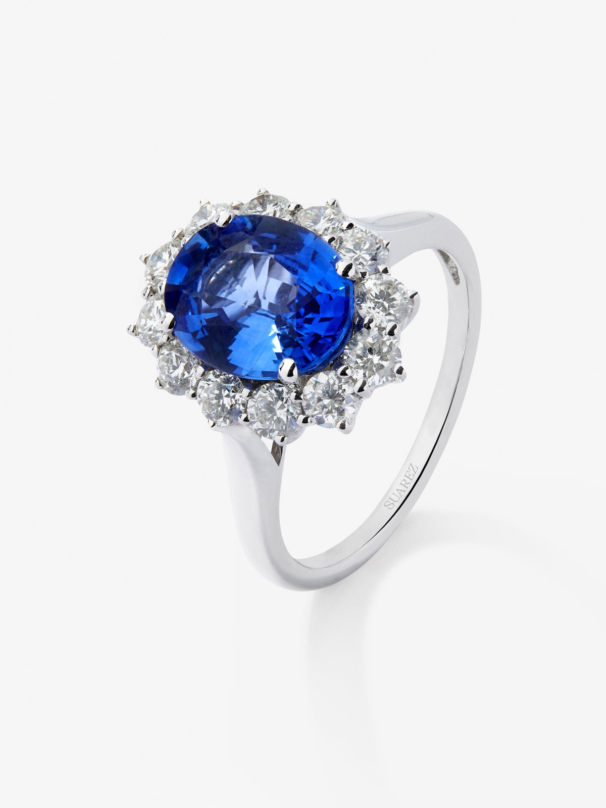 Anillo de oro blanco de 18K con zafiro azul royal en talla oval de 2,33 cts y orla de 12 diamantes en talla brillante con un total de 0,52 cts